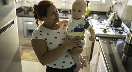 An early childhood educator providing care to an infant from her home